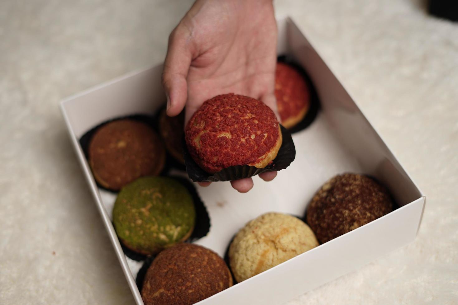 El craquelin choux es un canutillo japonés con una capa crujiente que tiene un sabor dulce y cremoso. creampuffs que contienen varios sabores de fla, vainilla, chocolate, matcha. eid cestas o paquetes. desenfoque de enfoque foto