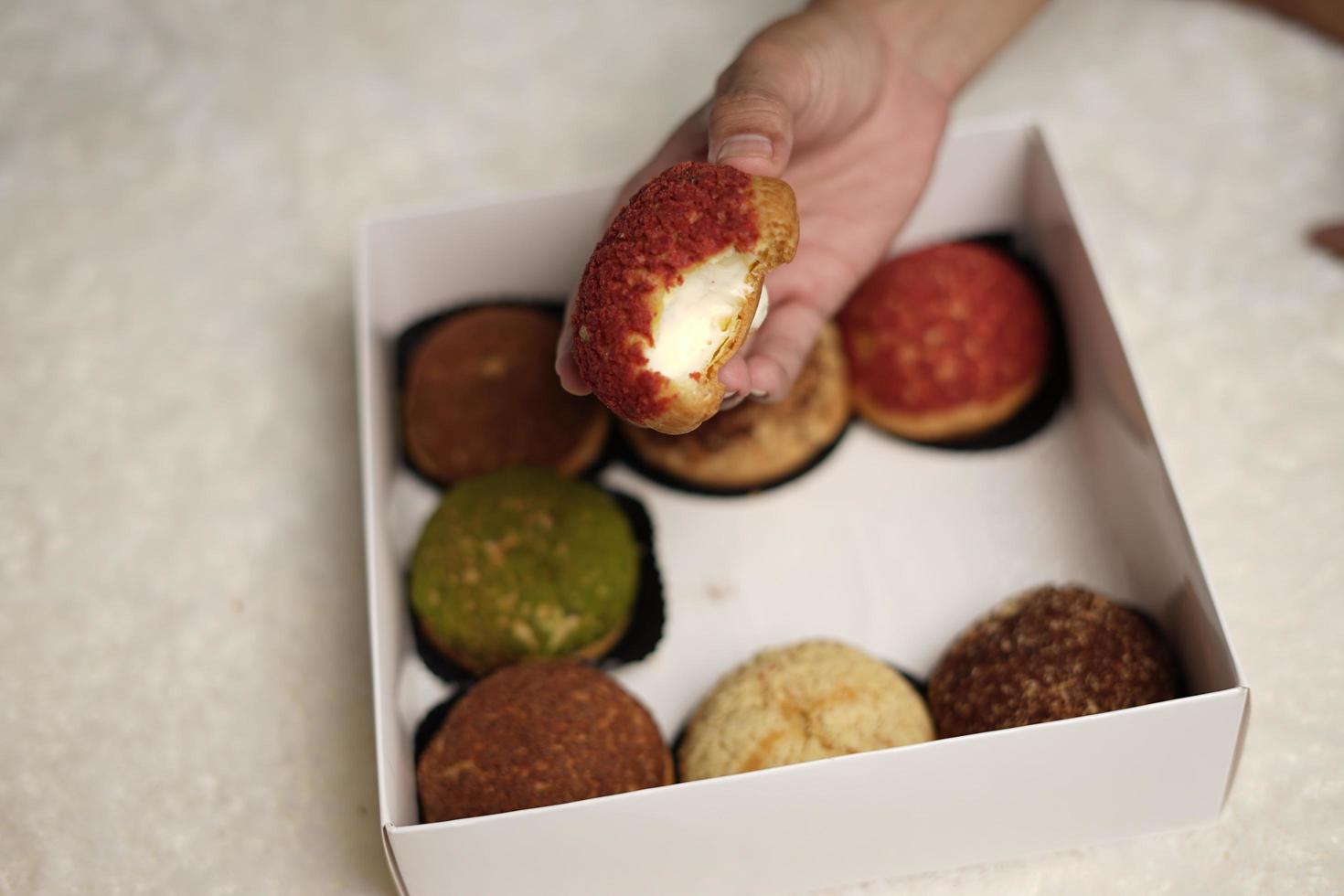 El craquelin choux es un canutillo japonés con una capa crujiente que tiene un sabor dulce y cremoso. creampuffs que contienen varios sabores de fla, vainilla, chocolate, matcha. eid cestas o paquetes. desenfoque de enfoque foto