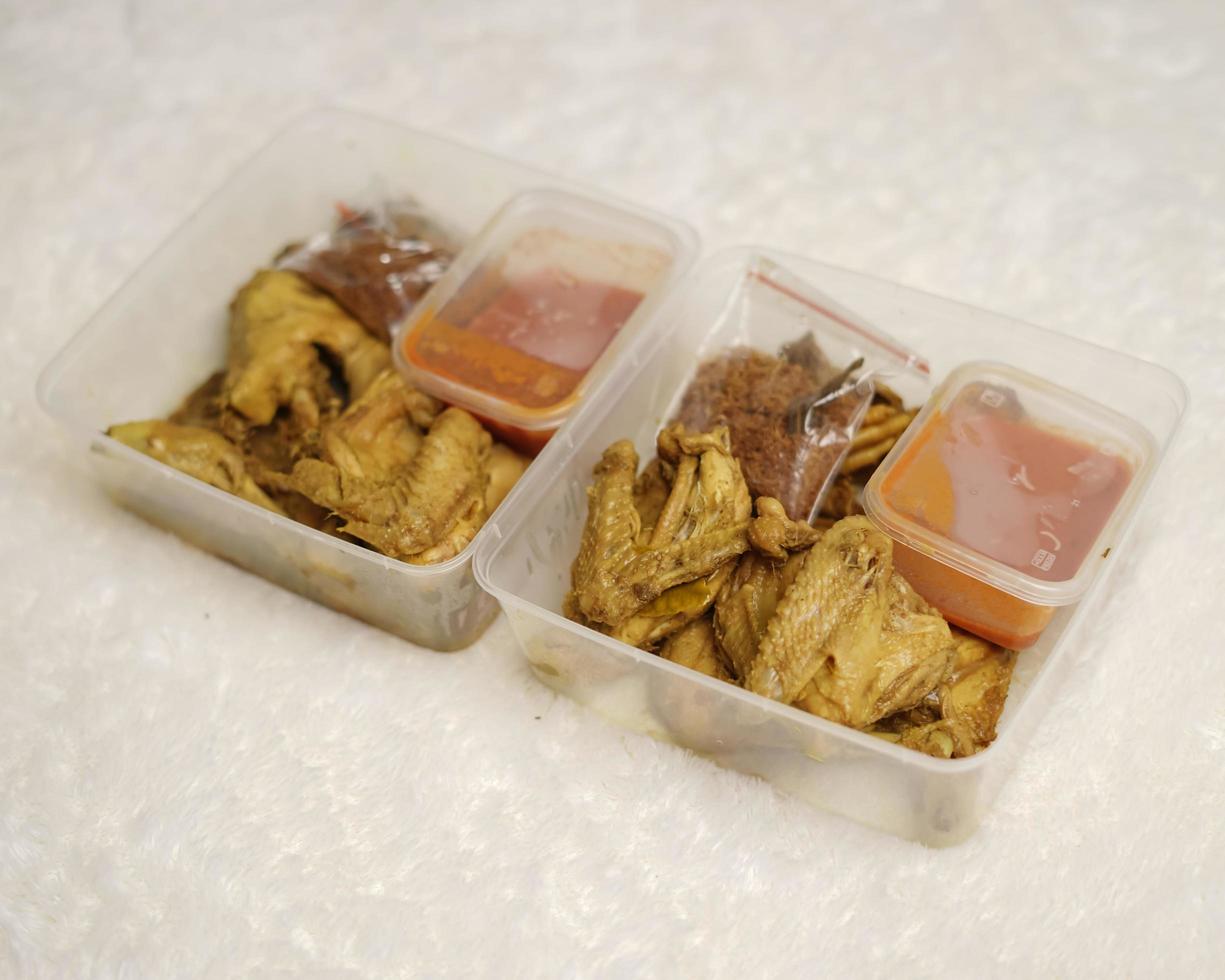 Chicken wrapped with Indonesian spices. Chicken pieces are ready to be fried. Ready-to-eat food in box packaging complete with chili sauce etc. Food packaging mockup box for template. Focus blur. photo