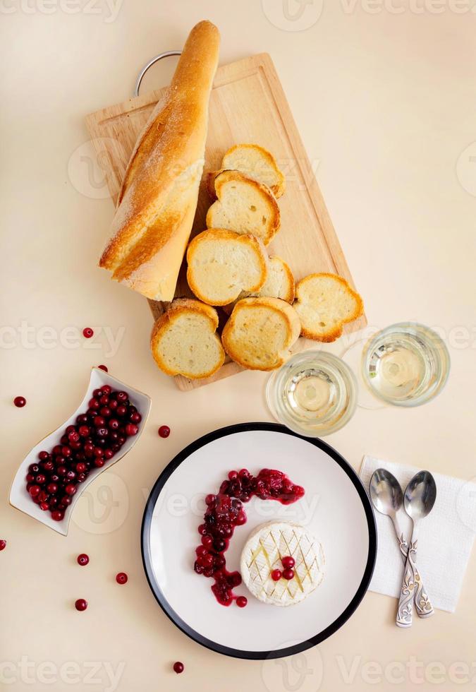 camembert al horno con arándanos y pan tostado. vista superior foto