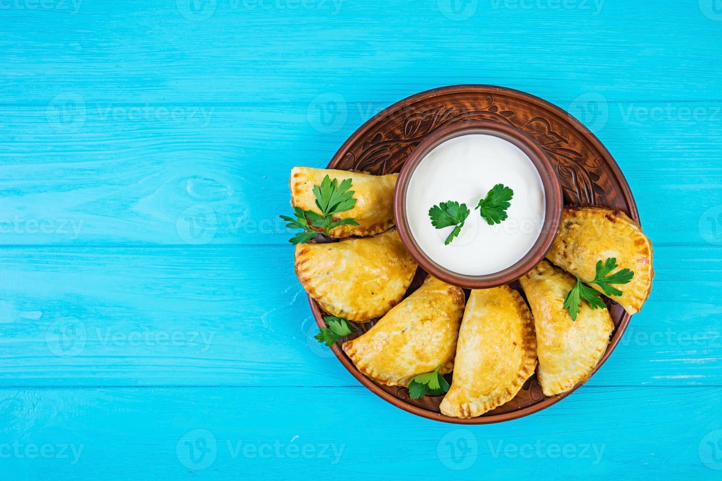 Delicious baked empanadas on wooden background photo