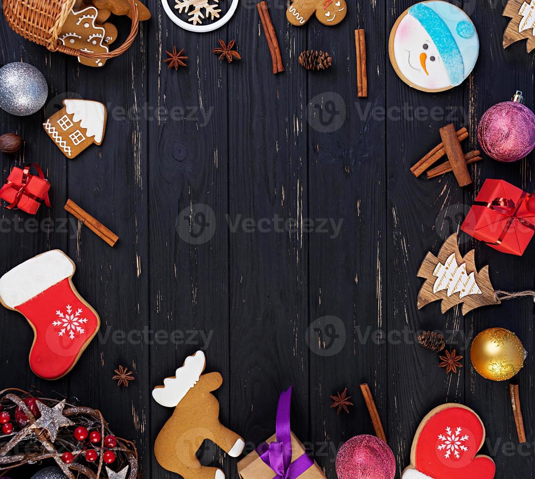 fondo de navidad. regalo de navidad, juguetes, galletas de jengibre, especias y decoraciones sobre fondo de madera. vista superior foto