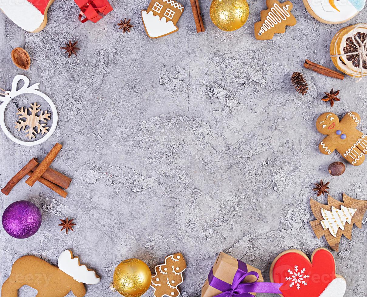 fondo de navidad. regalo de navidad, juguetes, galletas de jengibre, especias y decoraciones sobre fondo de madera. vista superior foto