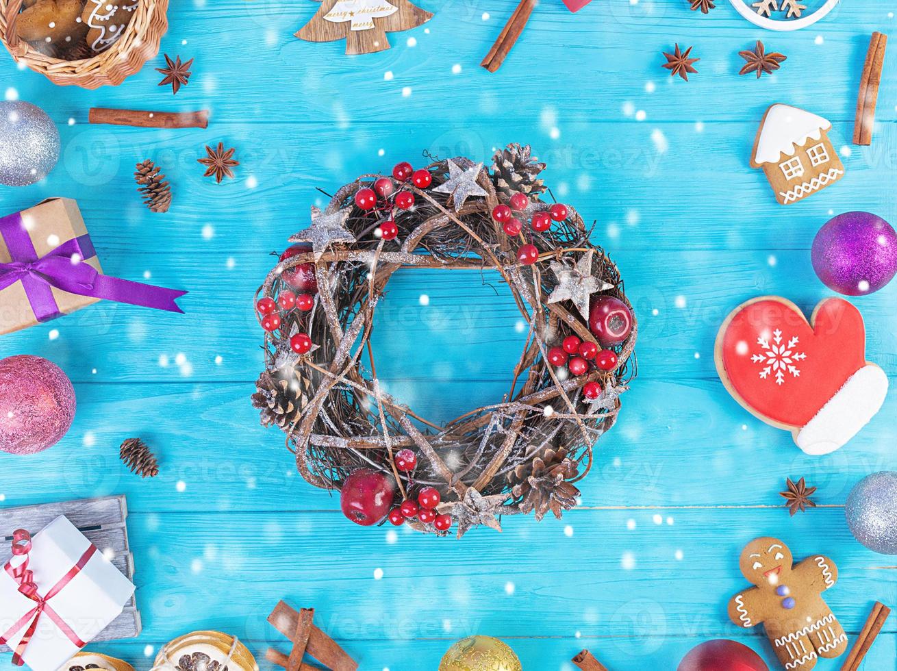 Christmas background. Christmas gift, toys, gingerbread cookies, spices and decorations on wooden background. Top view photo