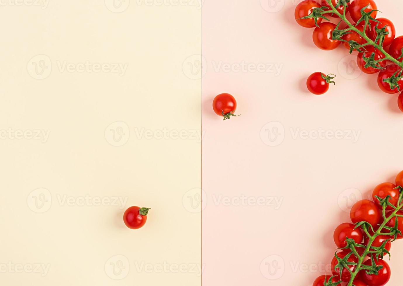 Isolated fresh red cherry tomatoes on yellow-beige background. Top view. Flat lay photo