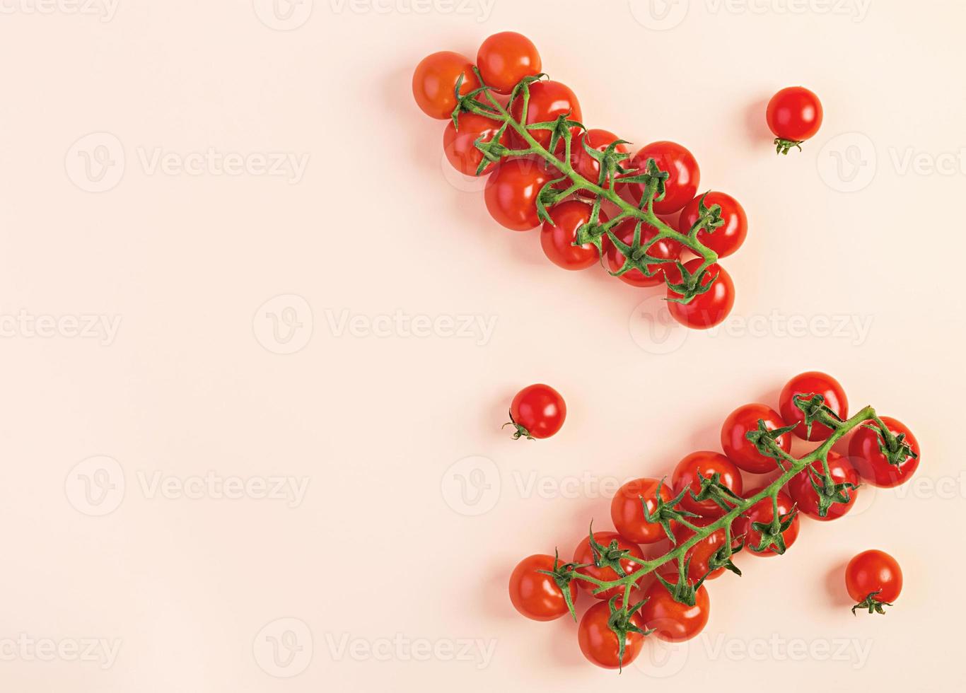 Isolated fresh red cherry tomatoes on beige background. Top view. Flat lay photo