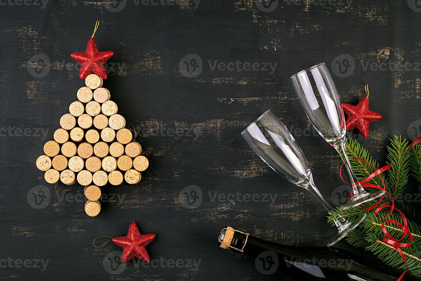 decoración de año nuevo con árbol de navidad hecho de corchos de vino y botella de champán. fondo de navidad. vista superior. foto