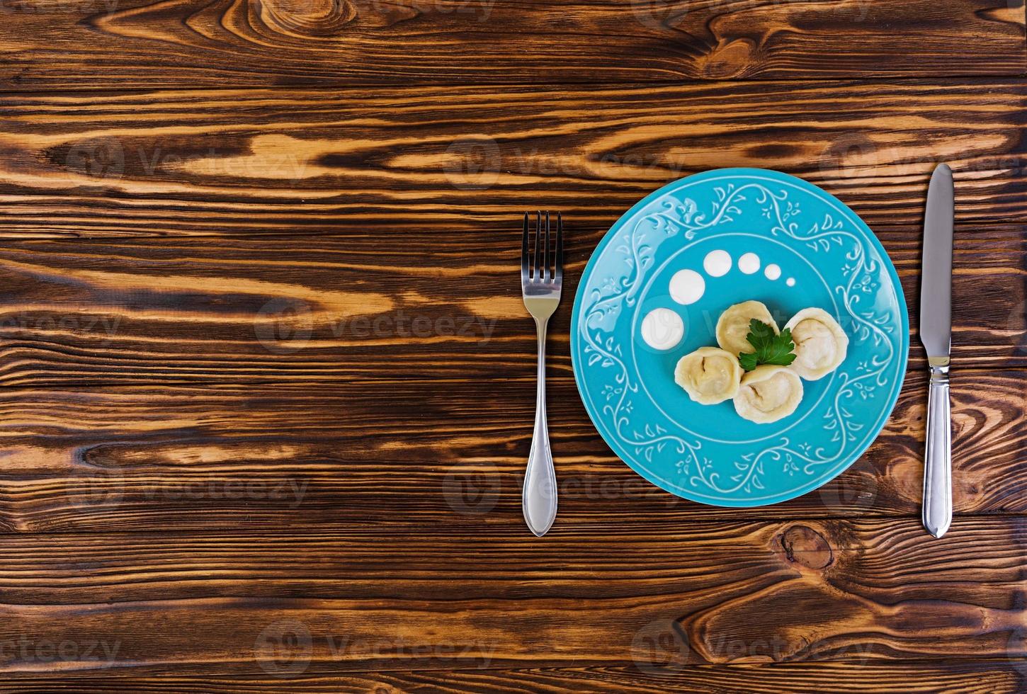 Delicious homemade dumplings, pelmeni, on wooden background photo