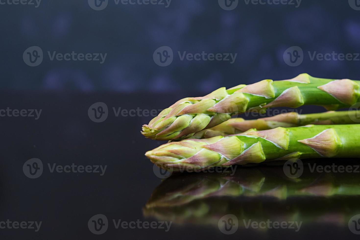 Fresh asparagus on dark background photo