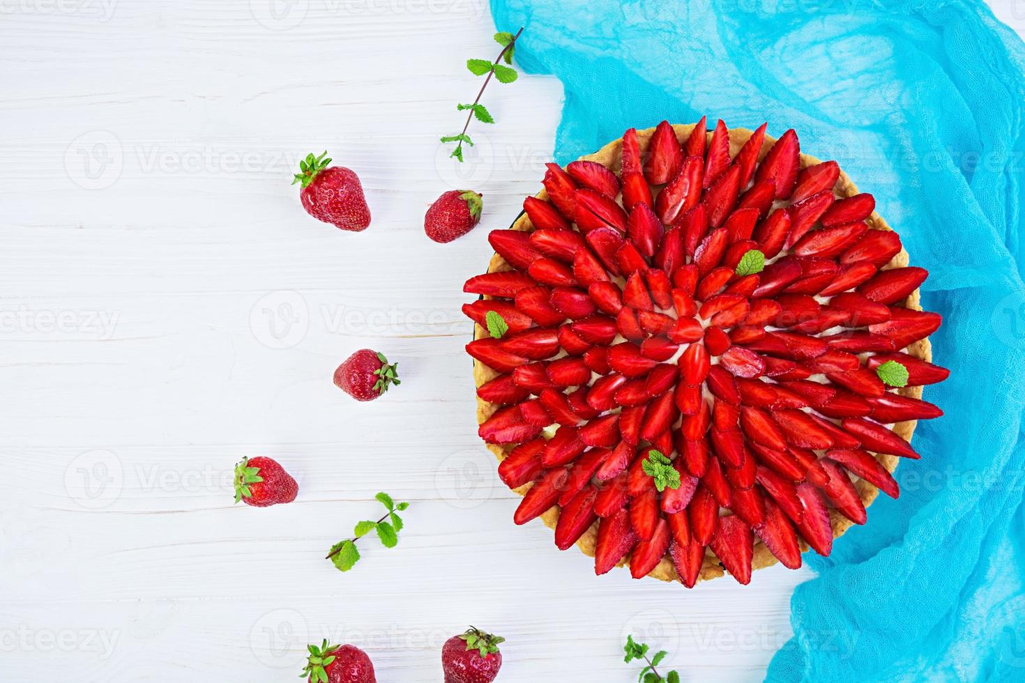 Delicious tart with strawberry on wooden background photo