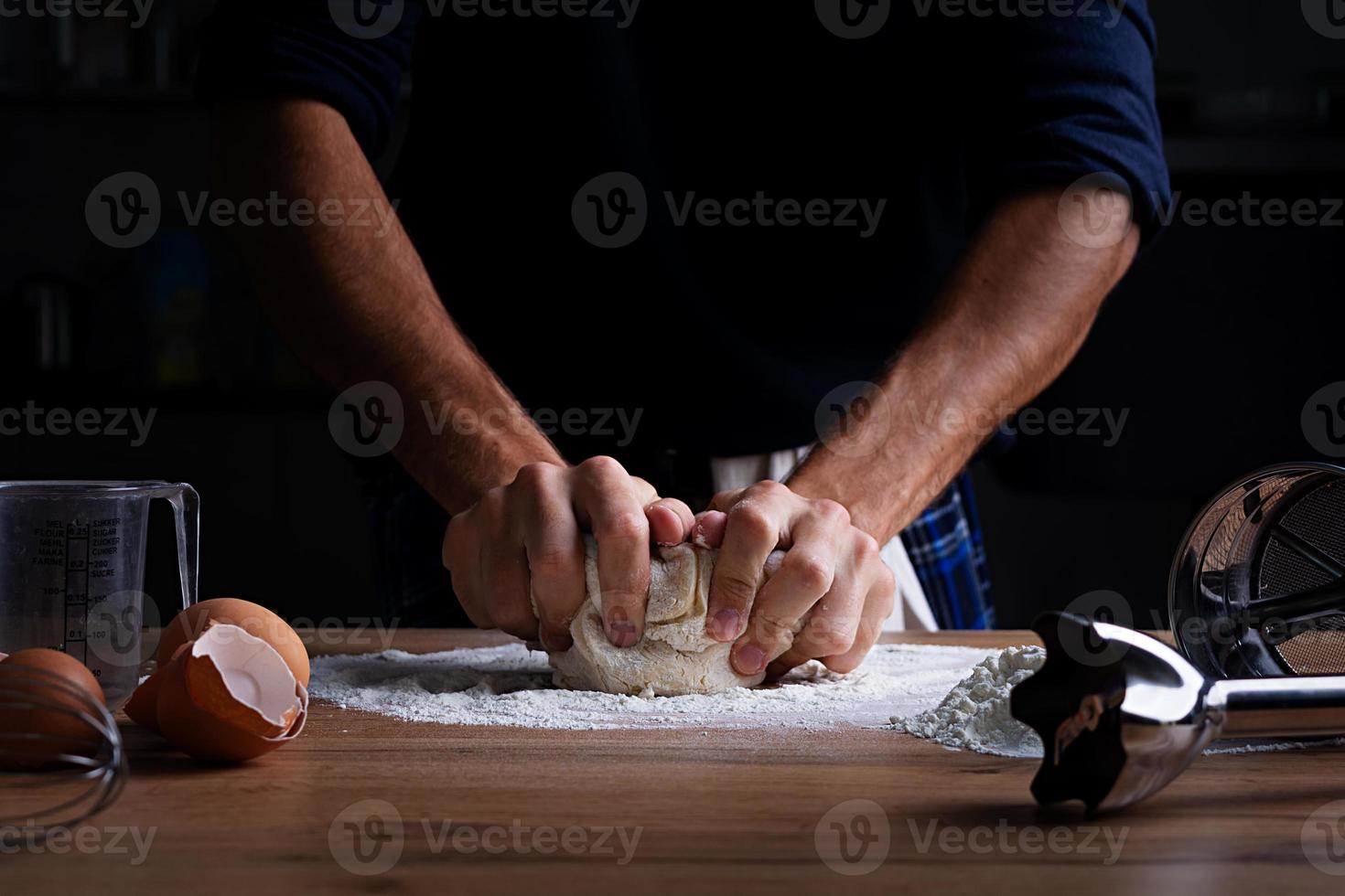 Male hands making dough for pizza, dumplings or bread. Baking concept. photo