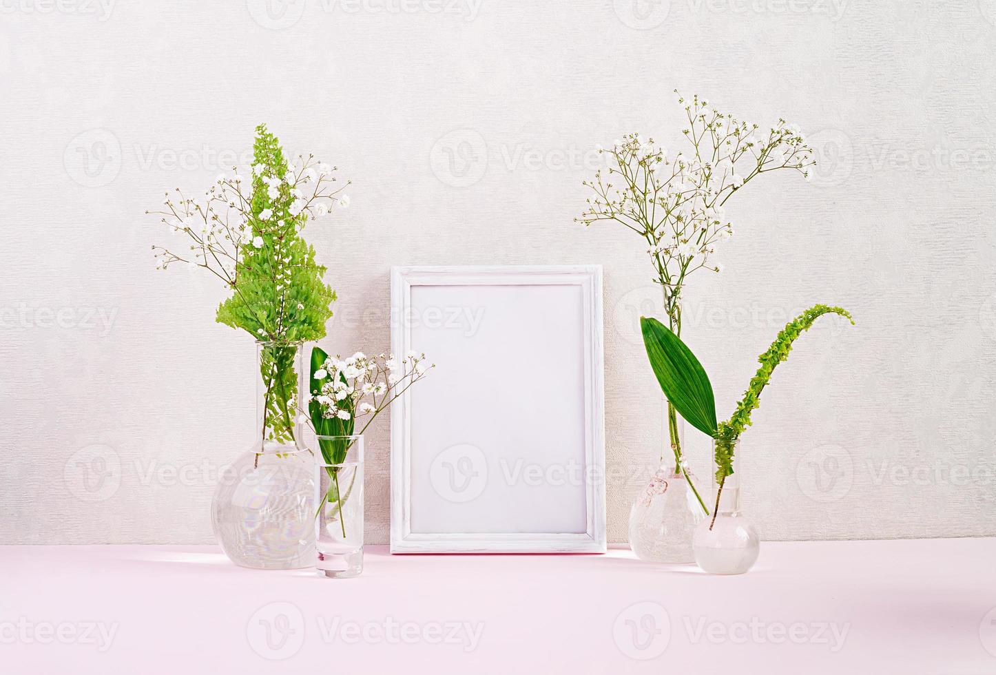 Flowers and plants in flask with frame. Beautiful spring background with flowers in vase. photo