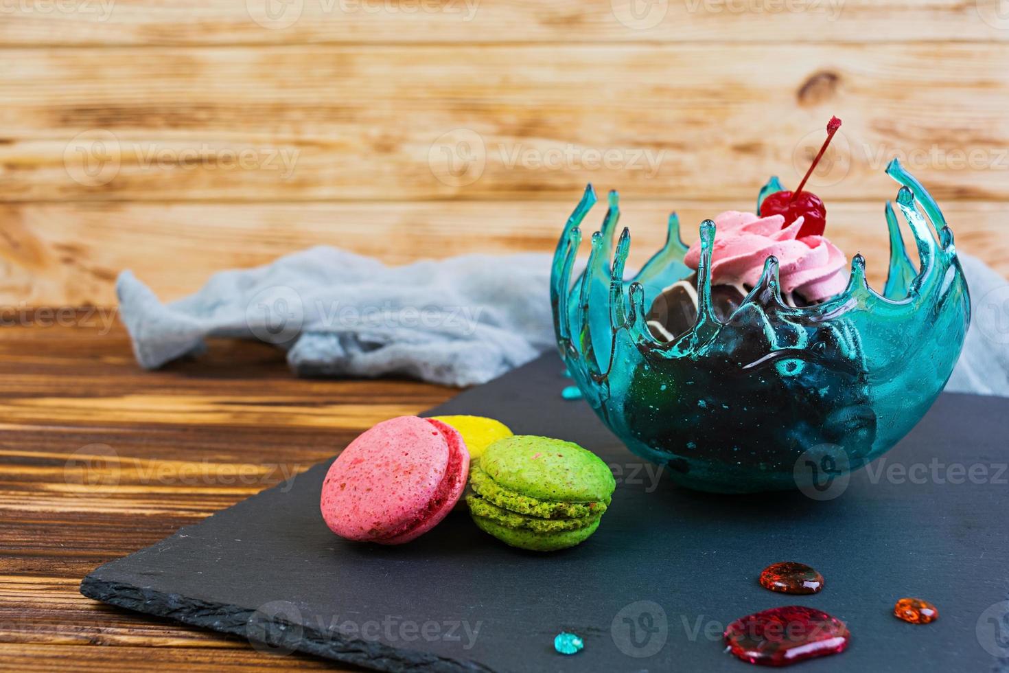 Sweet dessert and macaron in caramel bowl on wooden background photo