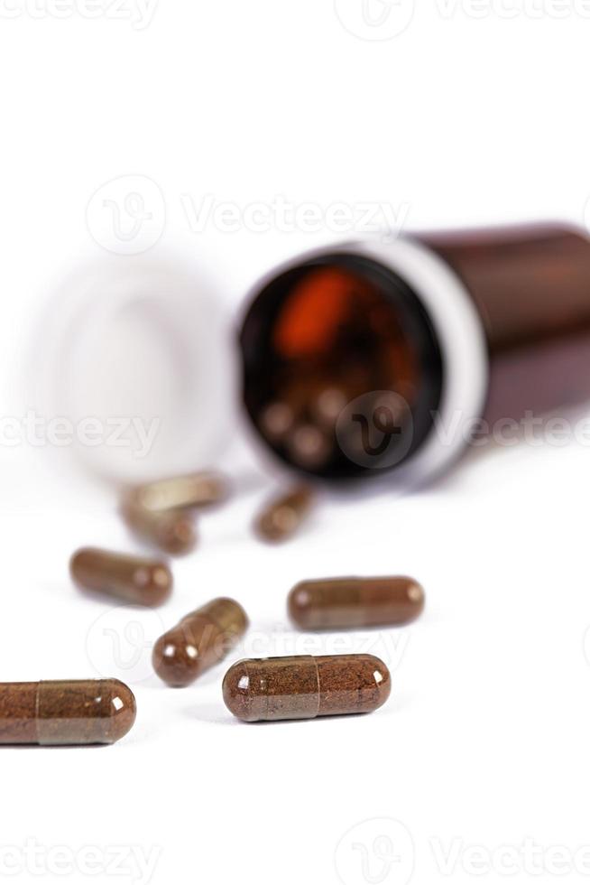 Pill bottle and scattered medical pills. Isolated medicaments. photo