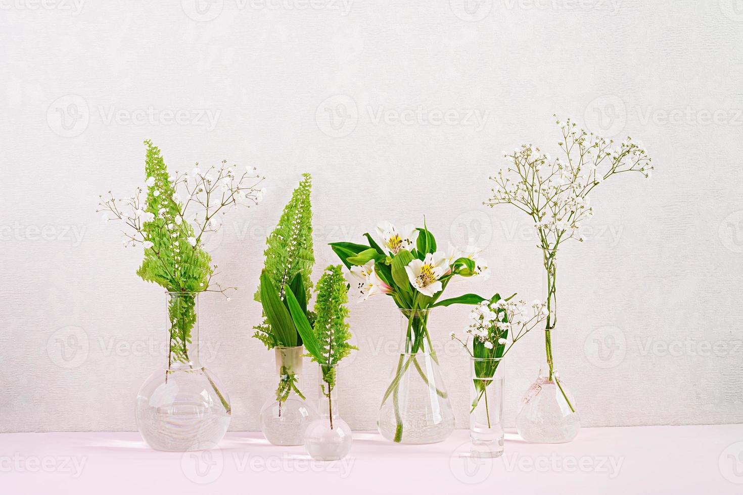 Flowers and plants in flask. Beautiful spring background with flowers in vase. photo