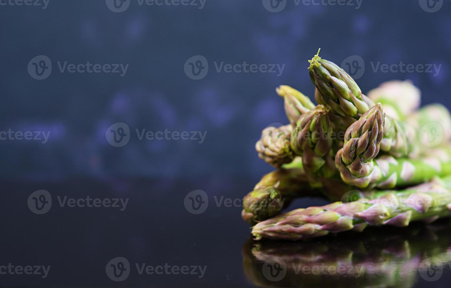 Fresh asparagus on dark background photo