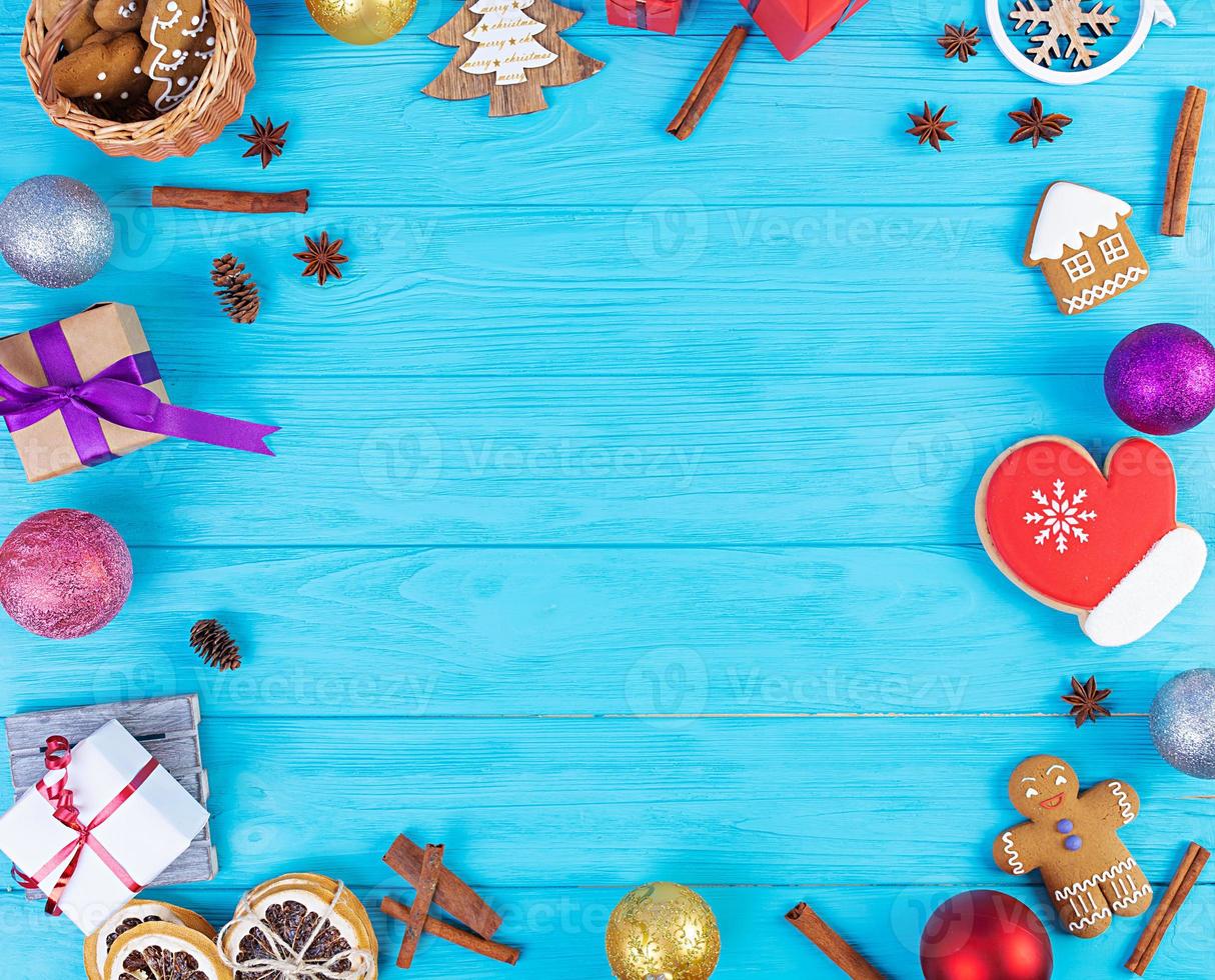 fondo de navidad. regalo de navidad, juguetes, galletas de jengibre, especias y decoraciones sobre fondo de madera. vista superior foto