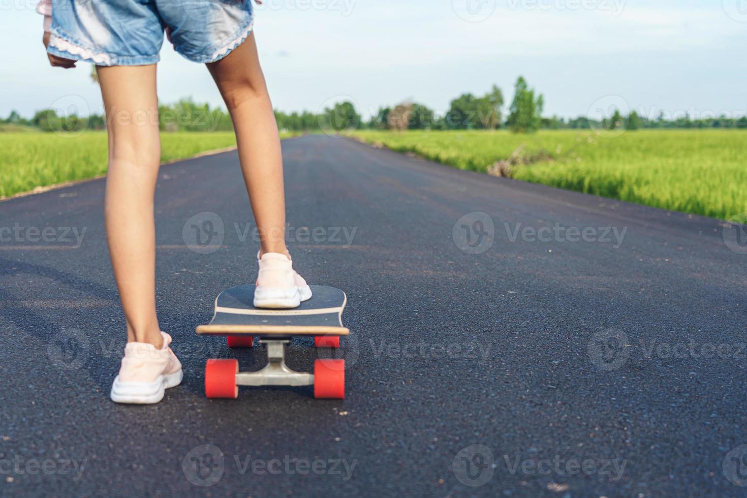 chica en surf skate con carretera en el campo. foto