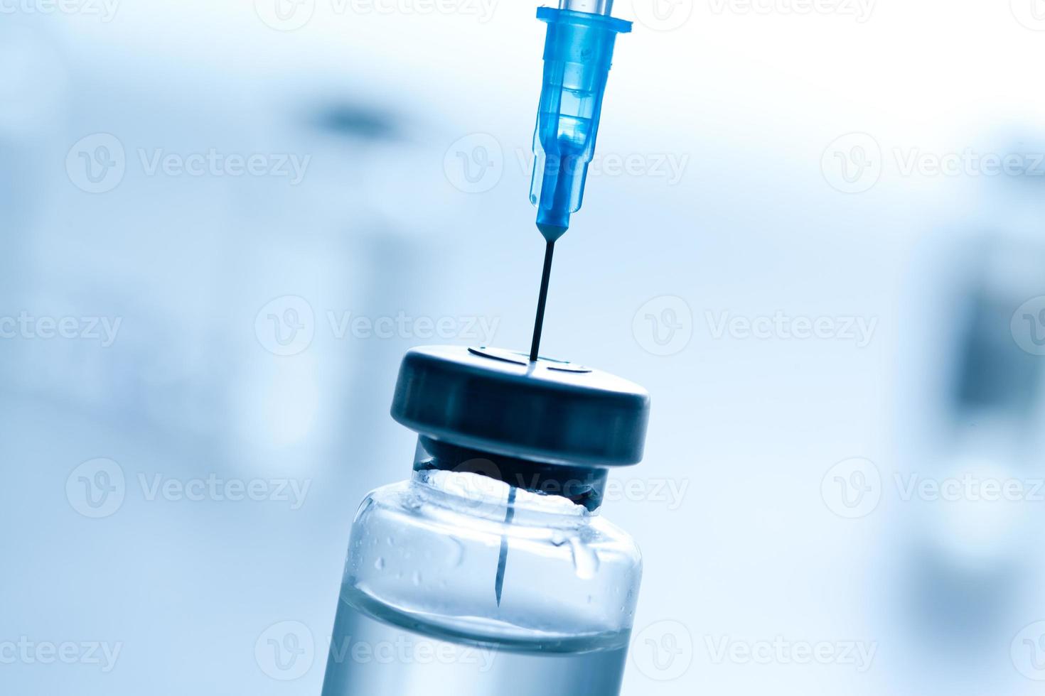 Medical syringe with a needle and a bollte with vaccine. photo