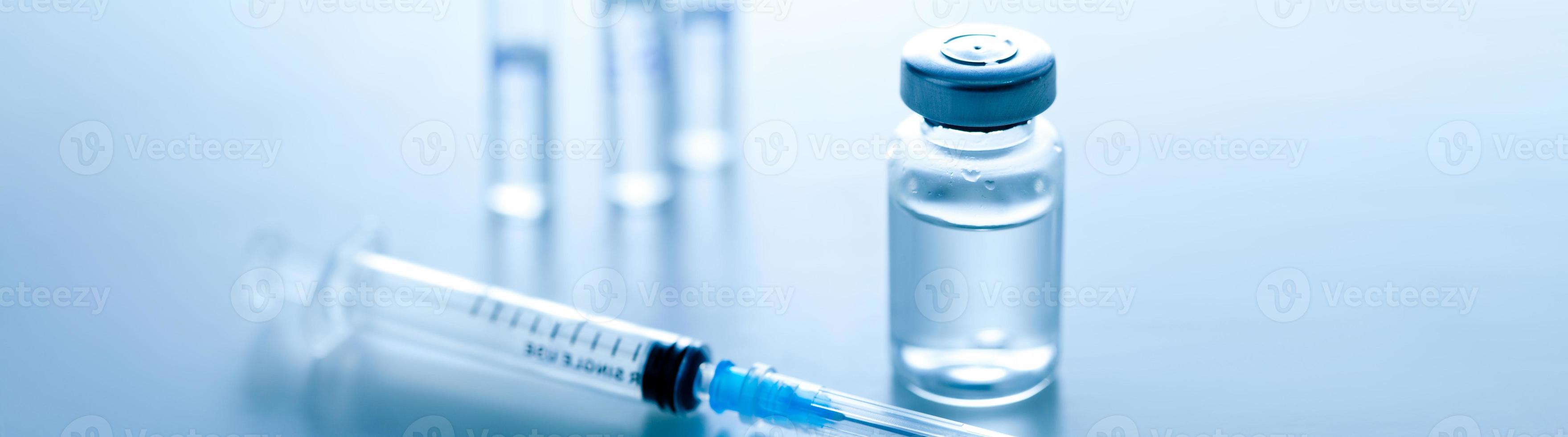 Medical syringe with a needle and a bollte with vaccine. photo