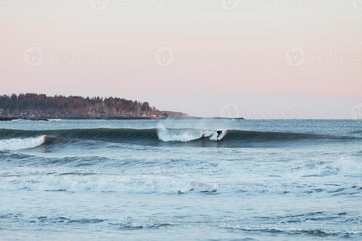 Surfer on a wave at dusk photo