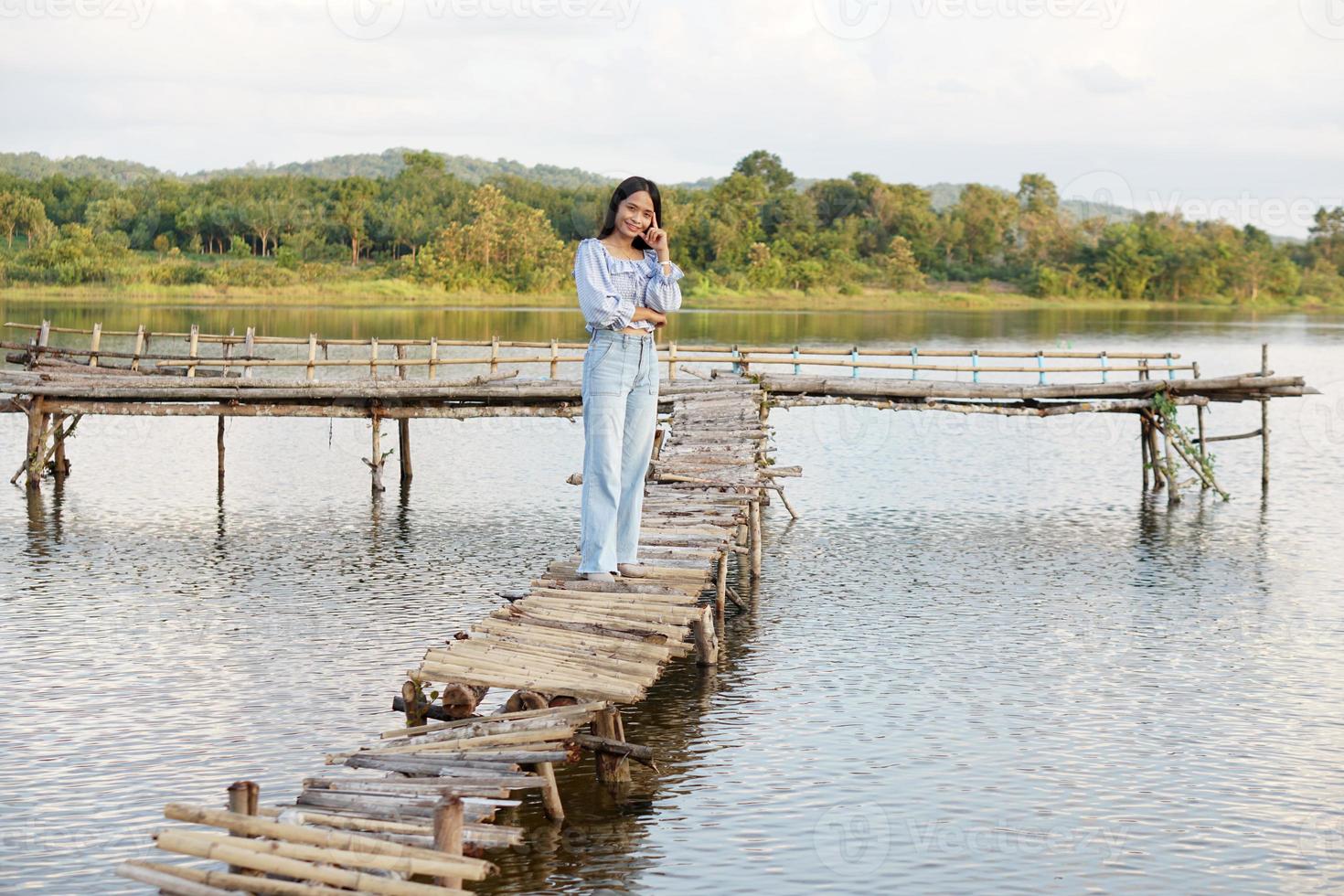 Asian woman in a light blue dress is walking happily in the middle of the meadow. photo