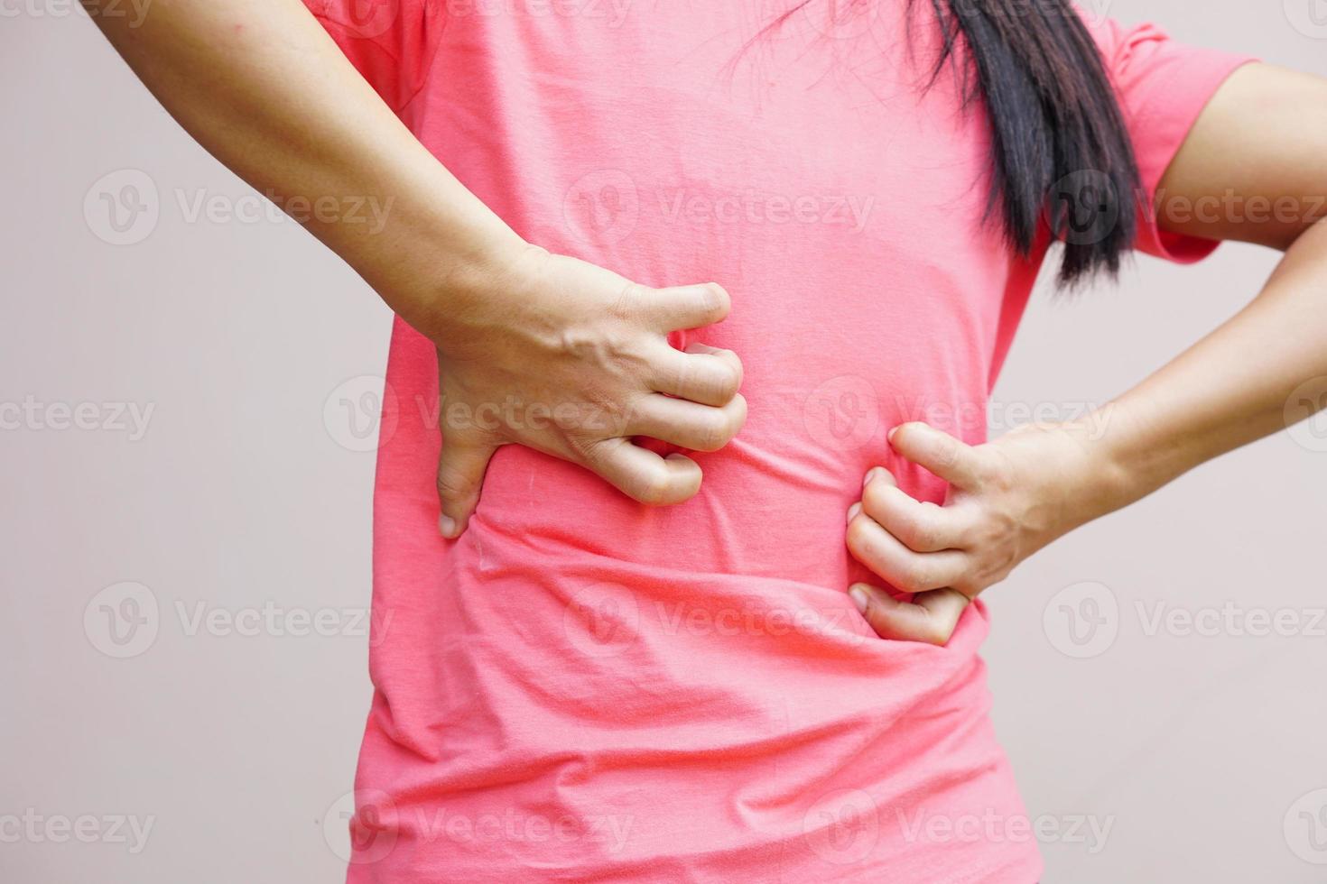 parte trasera de la mujer blanca dolor de espalda y concepto de dolor, mujer asiática con picazón en la espalda foto