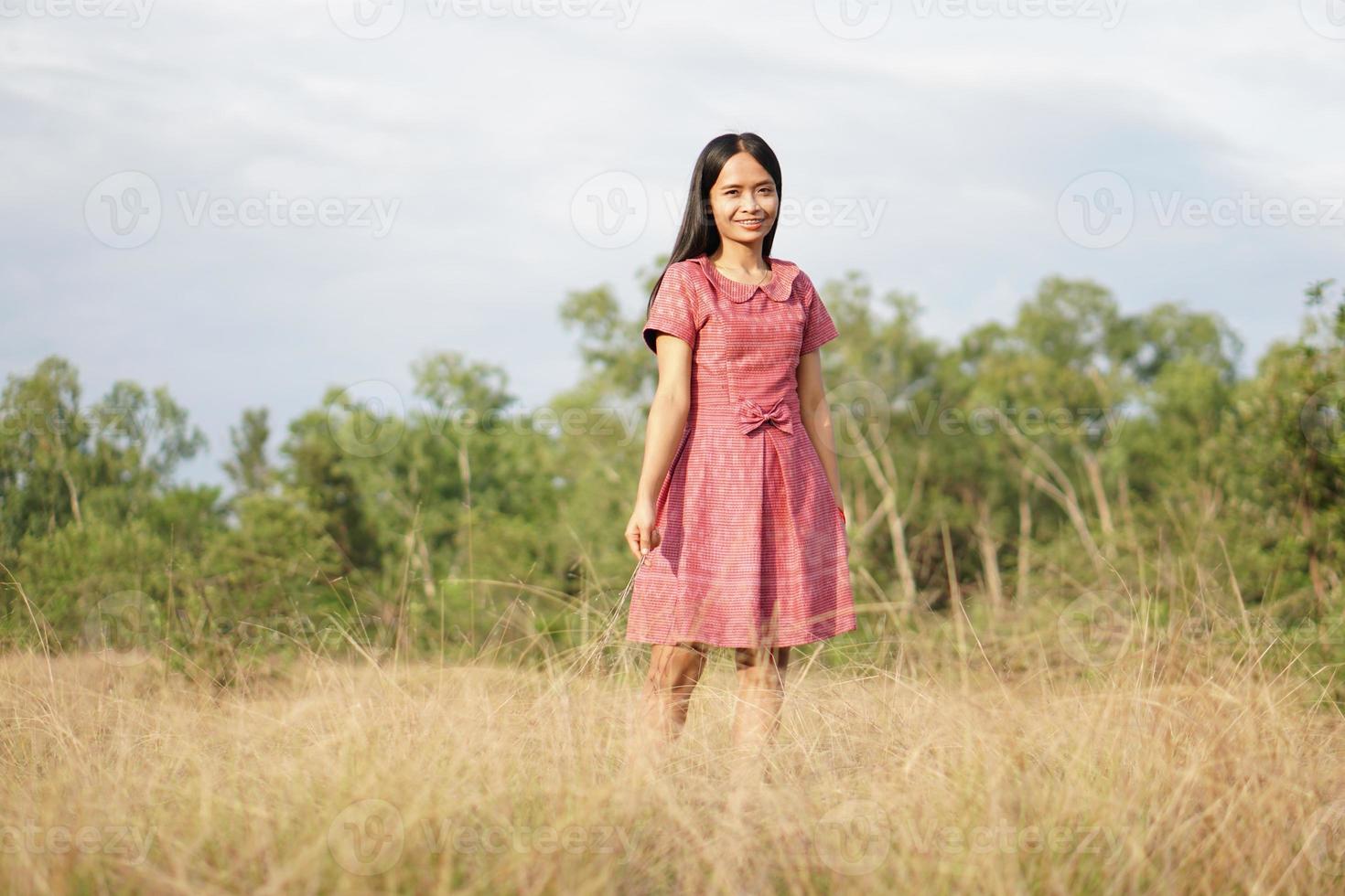 mujer asiática sonriendo alegremente levanta la mano hacia el fondo de la naturaleza del cielo foto