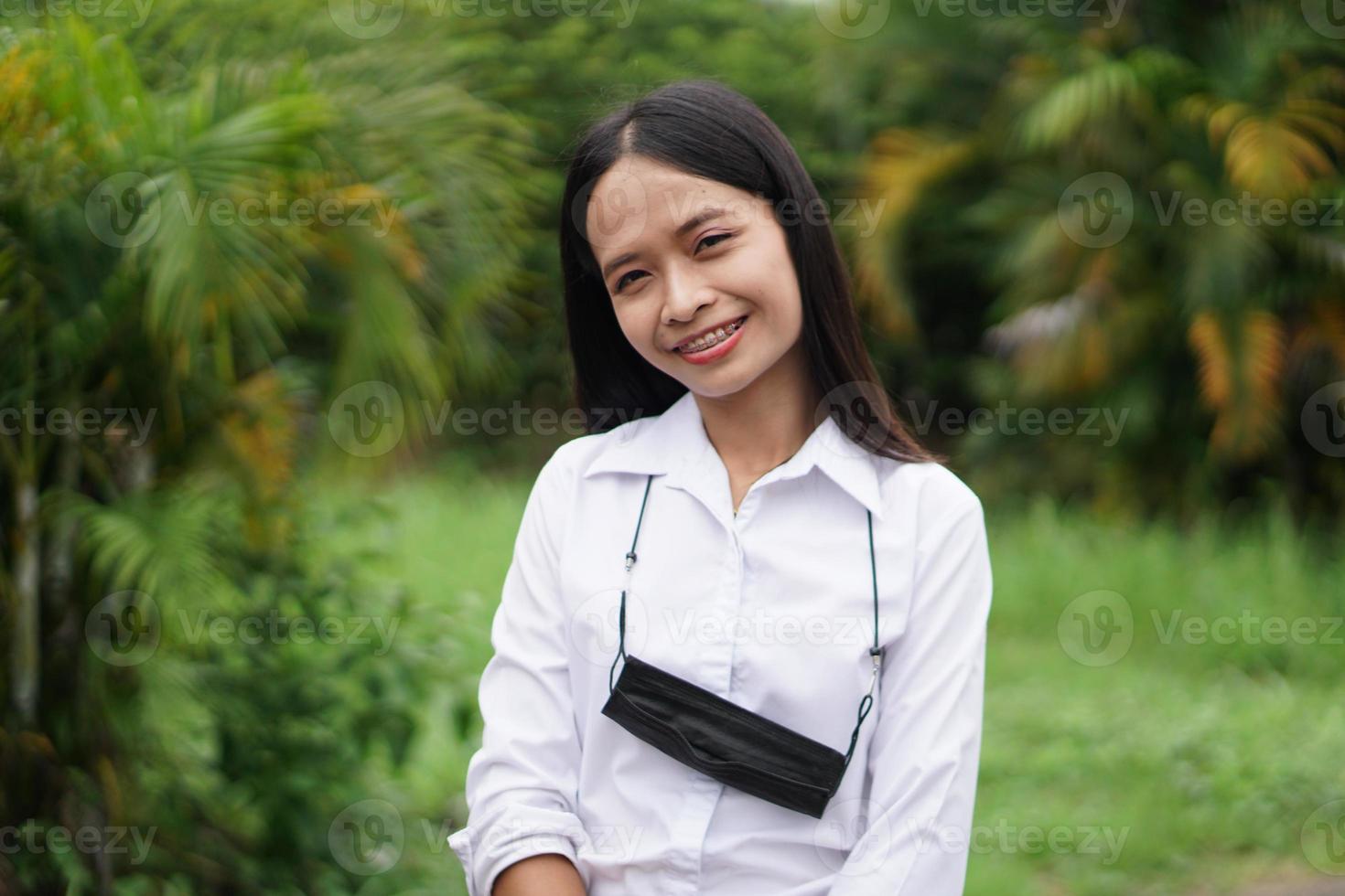 mujer asiática sonriendo alegremente levanta la mano hacia el fondo de la naturaleza del cielo foto