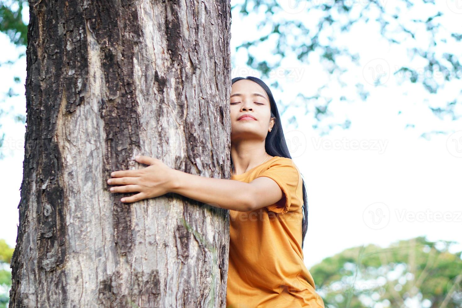 mujeres asiáticas abrazando árboles, el concepto de amor por el mundo foto