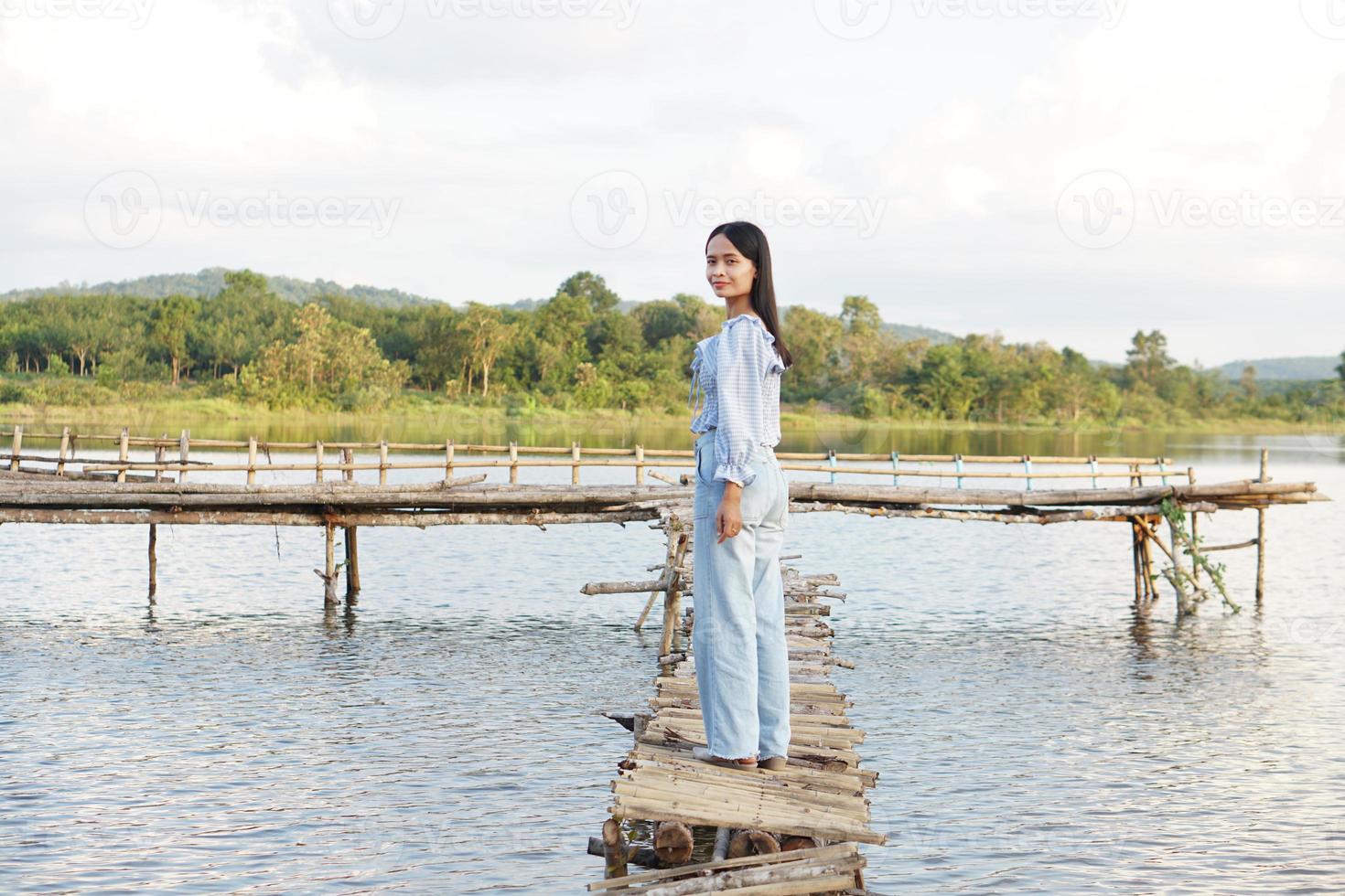 Asian woman in a light blue dress is walking happily in the middle of the meadow. photo