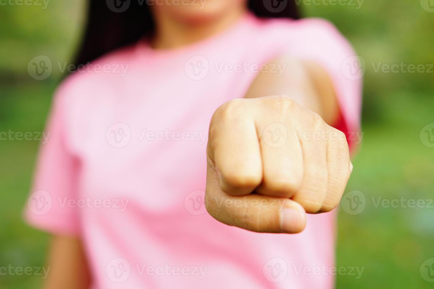 mujer levantando su puño al frente foto