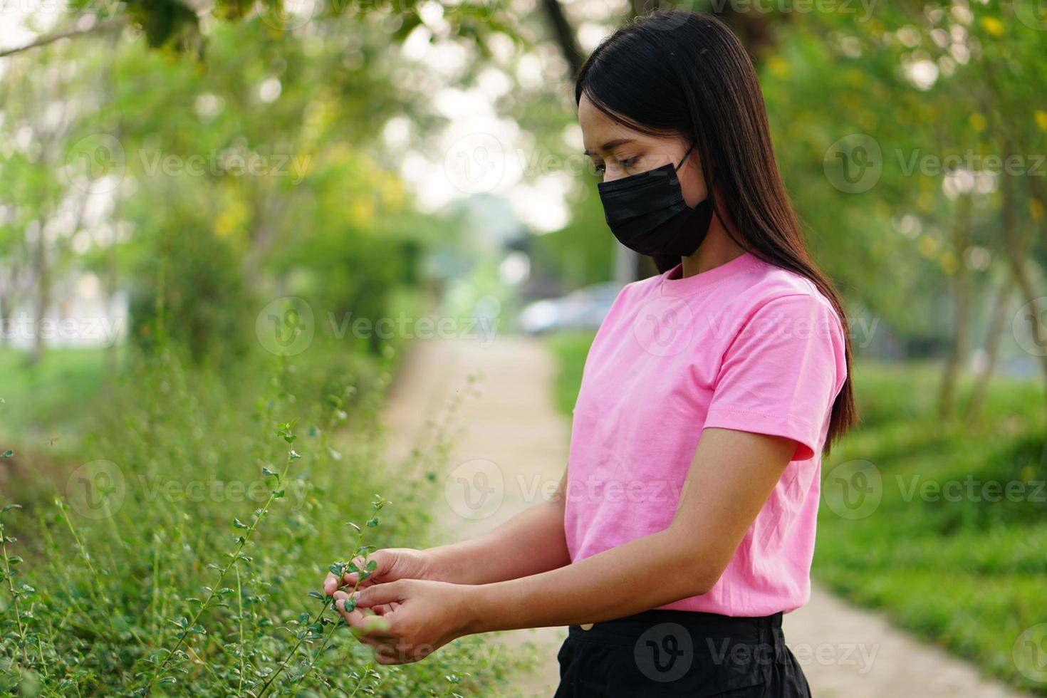 woman wearing a mask walks in the park. photo