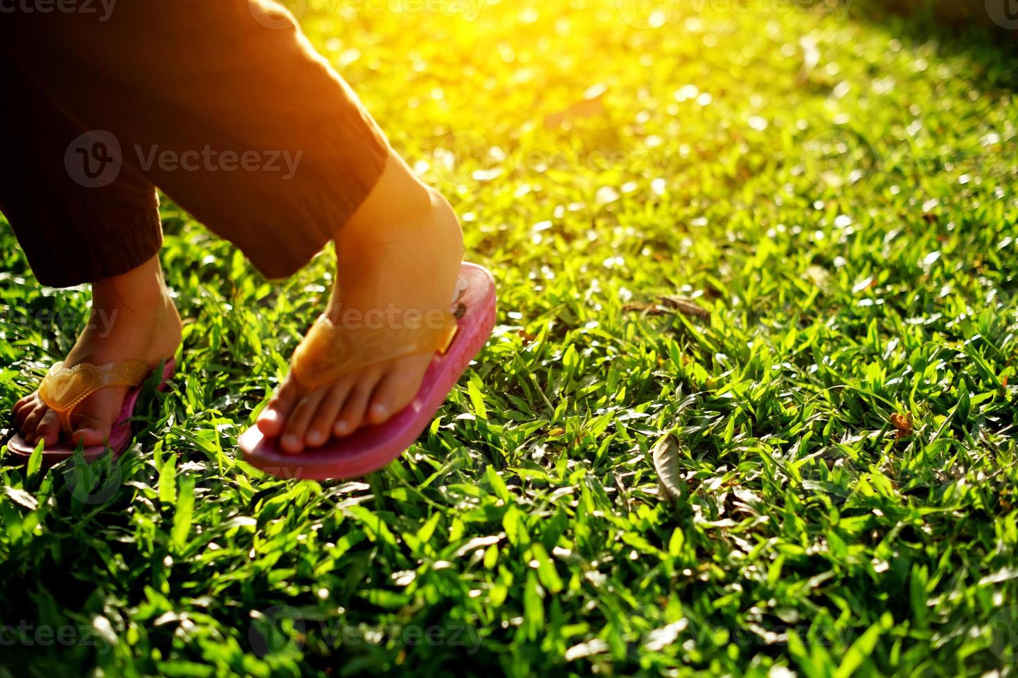 Foot part of a little girl in the park in the warm afternoon sun photo
