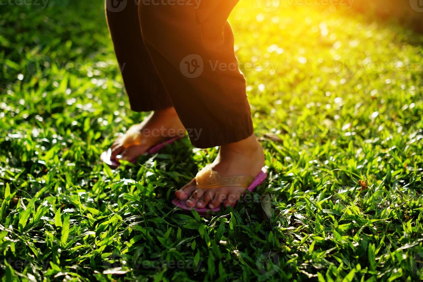 Foot part of a little girl in the park in the warm afternoon sun photo