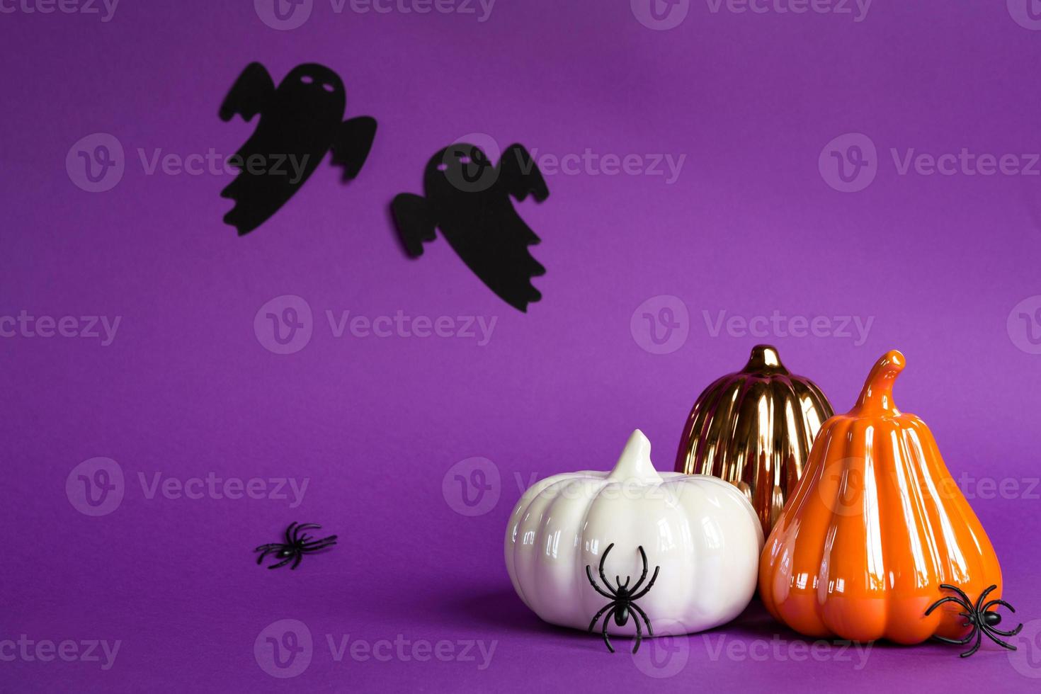 fondos de halloween de calabazas blancas, naranjas y doradas, arañas y fantasmas negros sobre un fondo morado con telarañas y paisajes terribles. horror y unas vacaciones aterradoras con espacio de copia foto