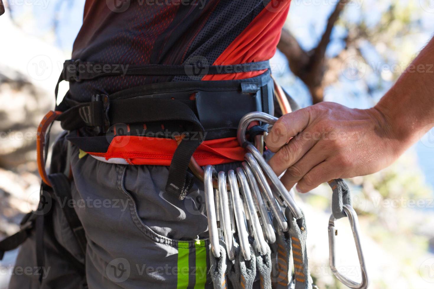 Climbing equipment on a male climber rock shoes, rope, quickdraw, safety device, harness. Sports mountain tourism, active lifestyle, extreme sports photo