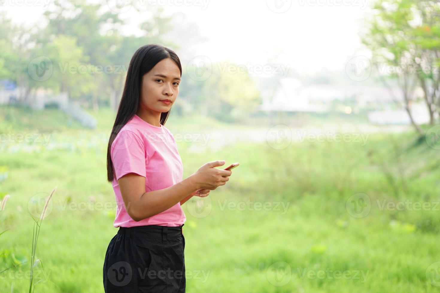 Asian woman using phone in park photo