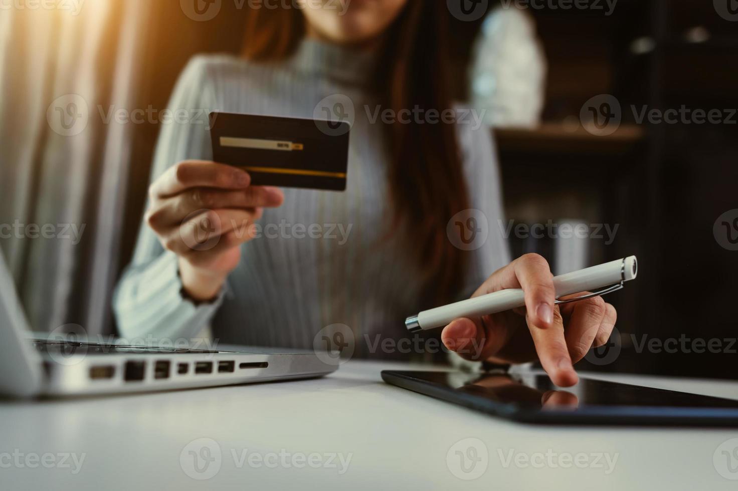 concepto de pagos de compras en línea. mano de mujer de negocios usando teléfonos inteligentes, pagos de tabletas y tarjeta de crédito foto