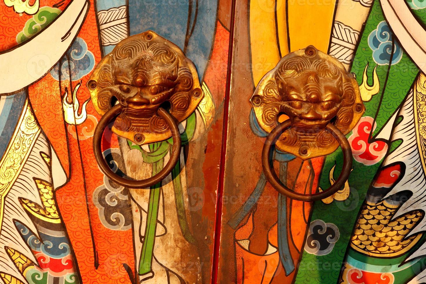 Brass door knobs are on bright colorful door and shape tiger head, the door knobs are design chinese style in shrine, Thailand. photo