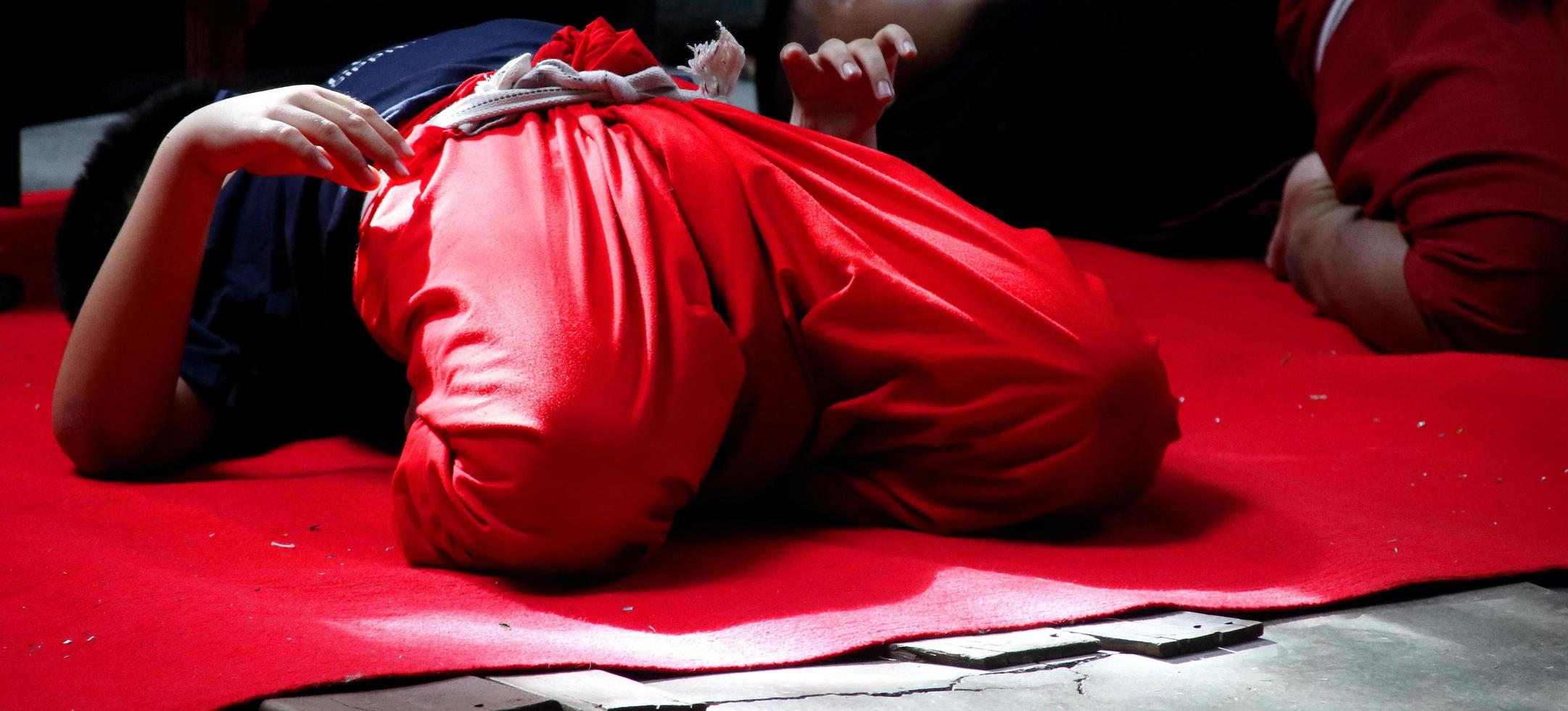 A children is practicing her body on red carpet for learning Khon, Bangkok. Khon is a dance drama genre in Thailand. photo