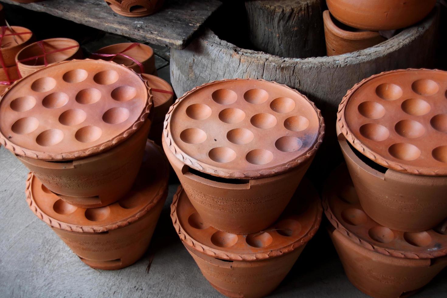 El juego de sartenes kanom krok hecho de arcilla se vende en una tienda, Tailandia. cacerola kamon krok en forma de estilo retro utilizada para hacer el nombre de postre tailandés es kanom krok. foto