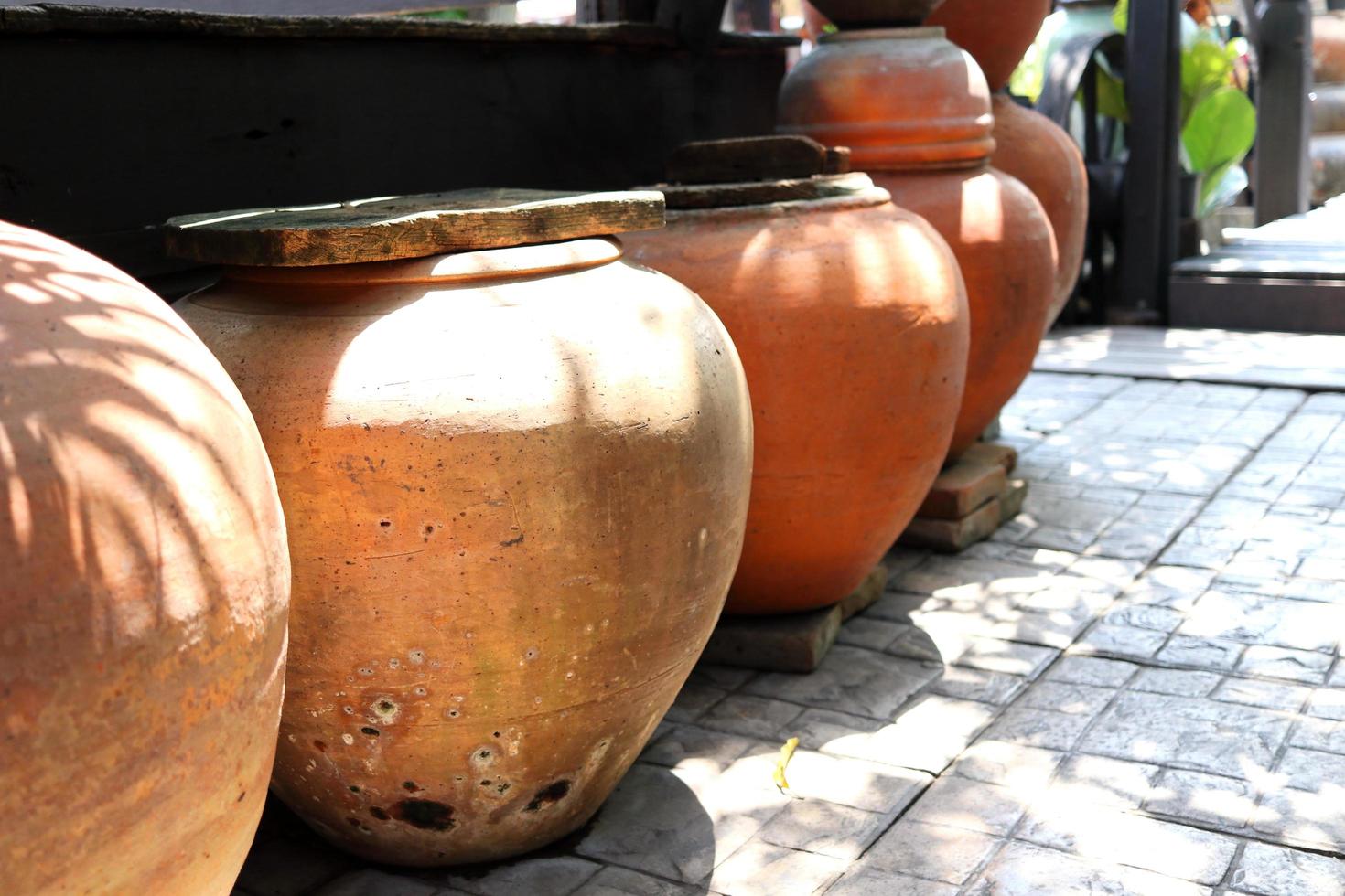 Row of earthen jars and rough gray floor, retro style jar in Thailand. photo