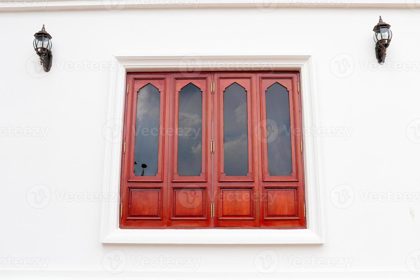 ventana de madera marrón roja y pared blanca, ventana de estilo retro cerrada. foto