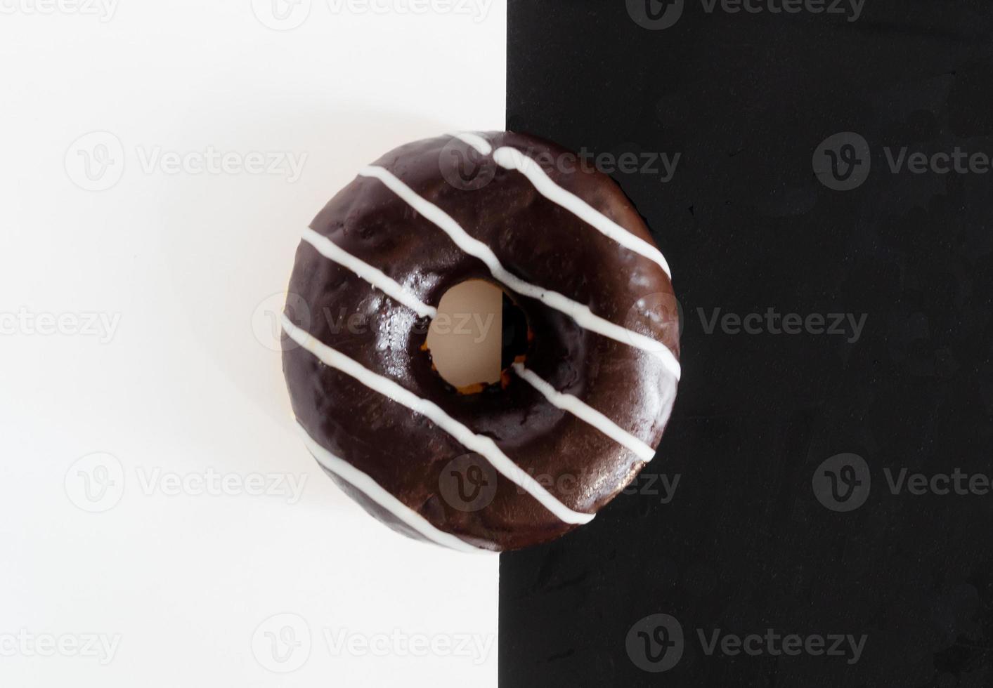 vista superior, donut de chocolate sobre fondo blanco negro foto