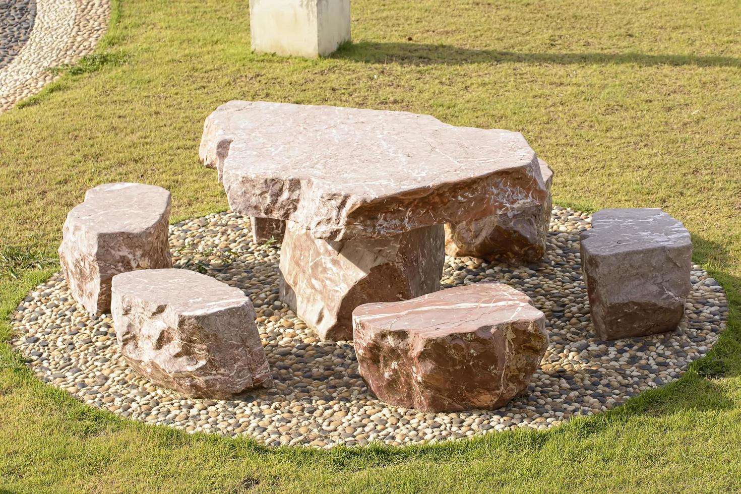 Marble table and chairs set on a nature background. photo