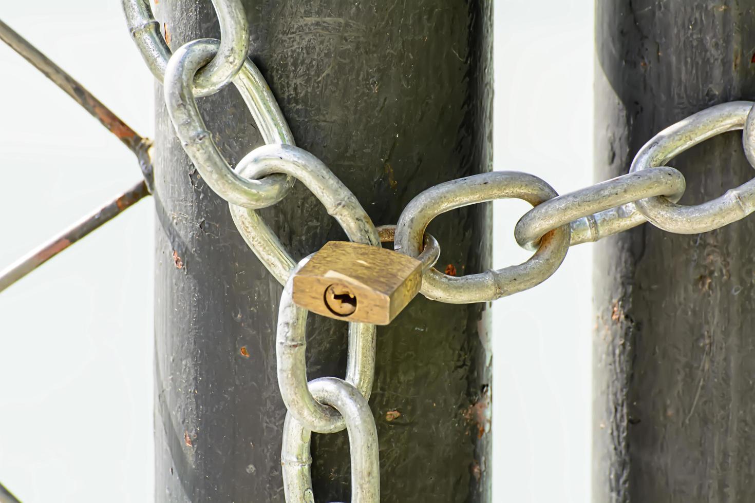 A lock and chain on Metal Fence that links of a gate. photo