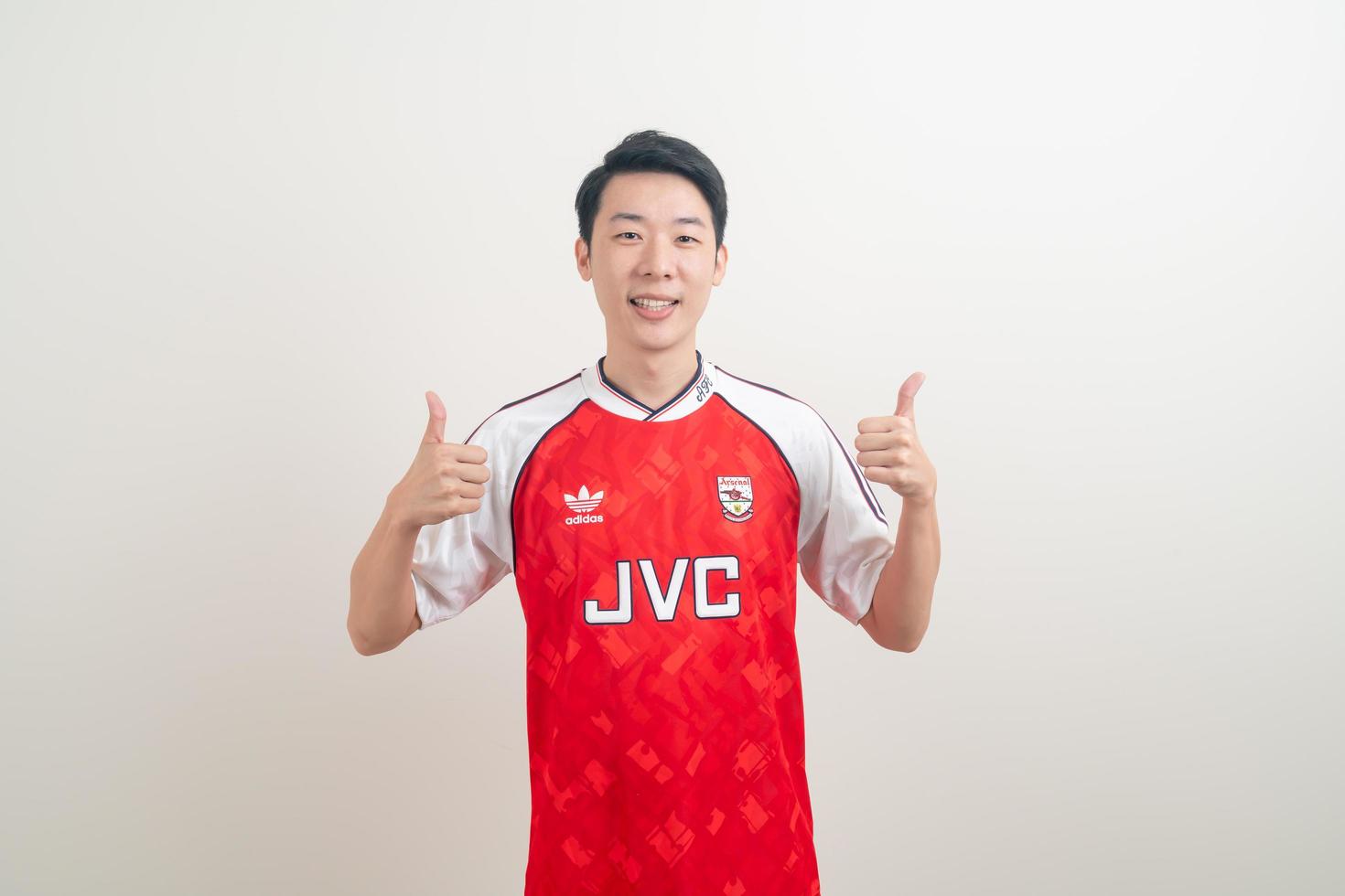 Bangkok, Tailandia - 27 de noviembre de 2021 - joven asiático vistiendo la camiseta del arsenal con fondo blanco. foto