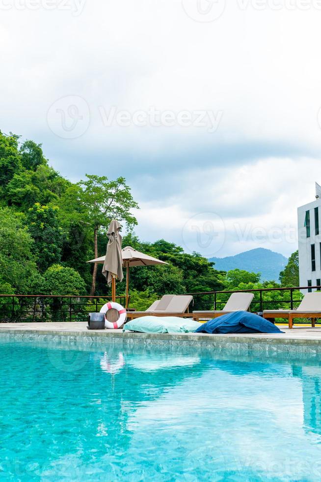 sombrilla y cama de piscina alrededor de la piscina foto