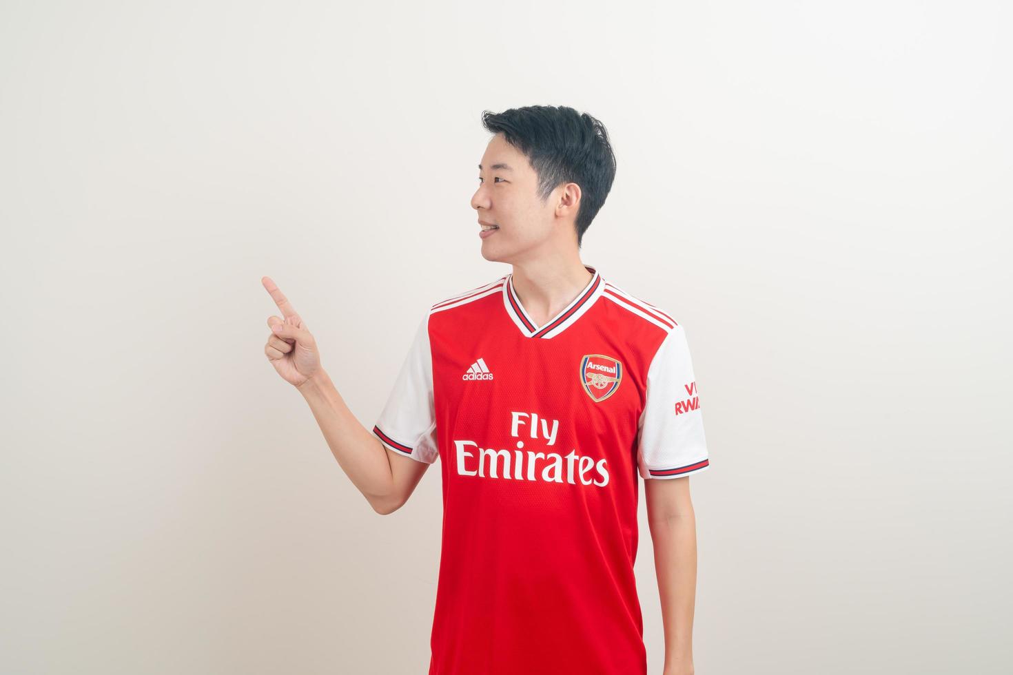 Bangkok, Tailandia - 27 de noviembre de 2021 - joven asiático vistiendo la camiseta del arsenal con fondo blanco. foto